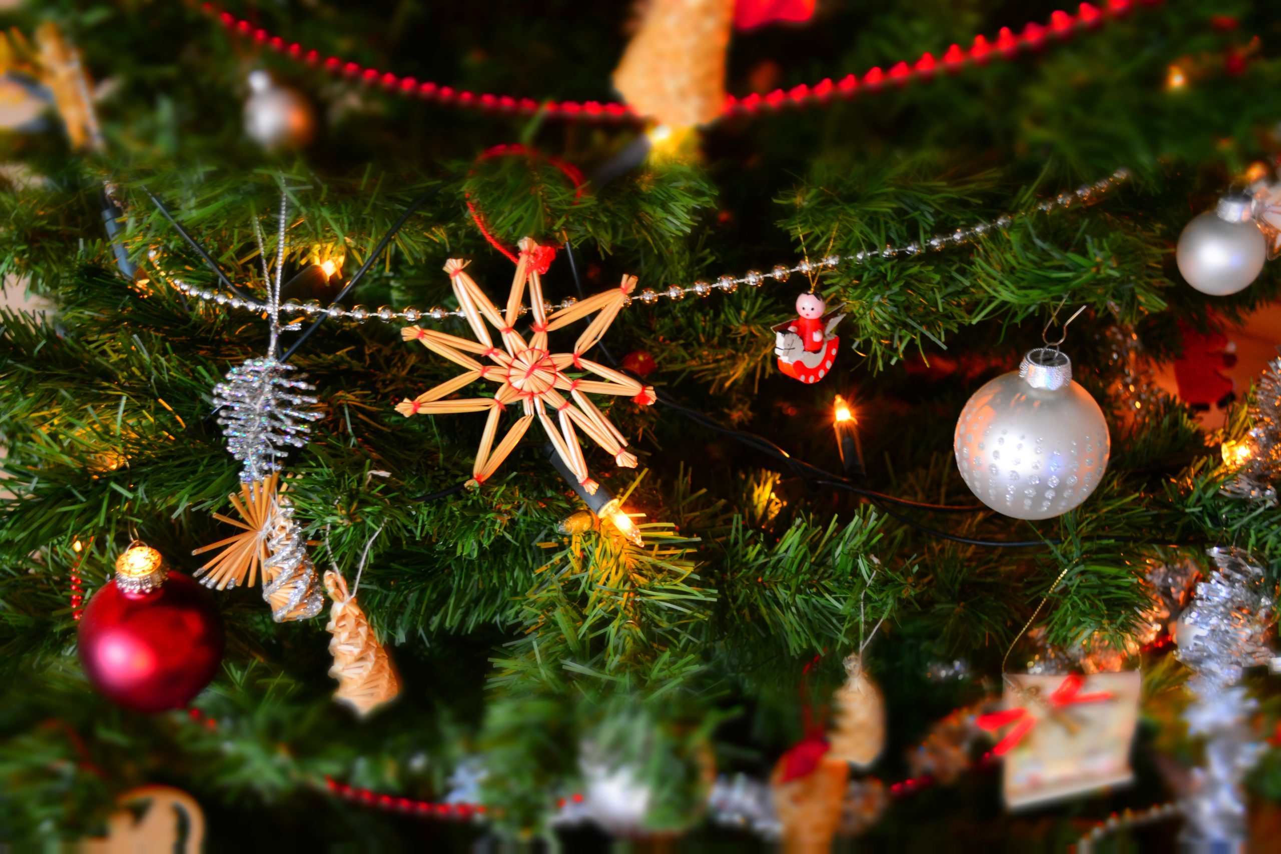 Close-up of Christmas tree with lights and hanging decorations
