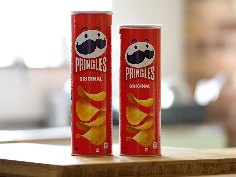 Two tubes of Pringles side by side with one taller than the other - showing the decrease in size of 'shrinkflation' of the product.