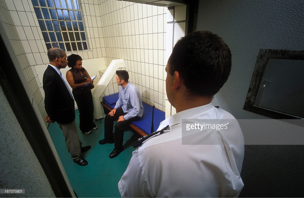 Independent Custody Lay Visitor visiting man in custody in is police cell UK