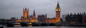 Image of the Houses of Parliament, London, UKBuildings and a clock tower behind a bridge and river.