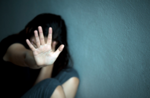 A Women with her hand up in front of her, depicting stopping sexual abuse.