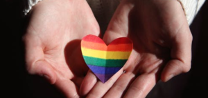 Cupping Hands with a Rainbow coloured paper heart