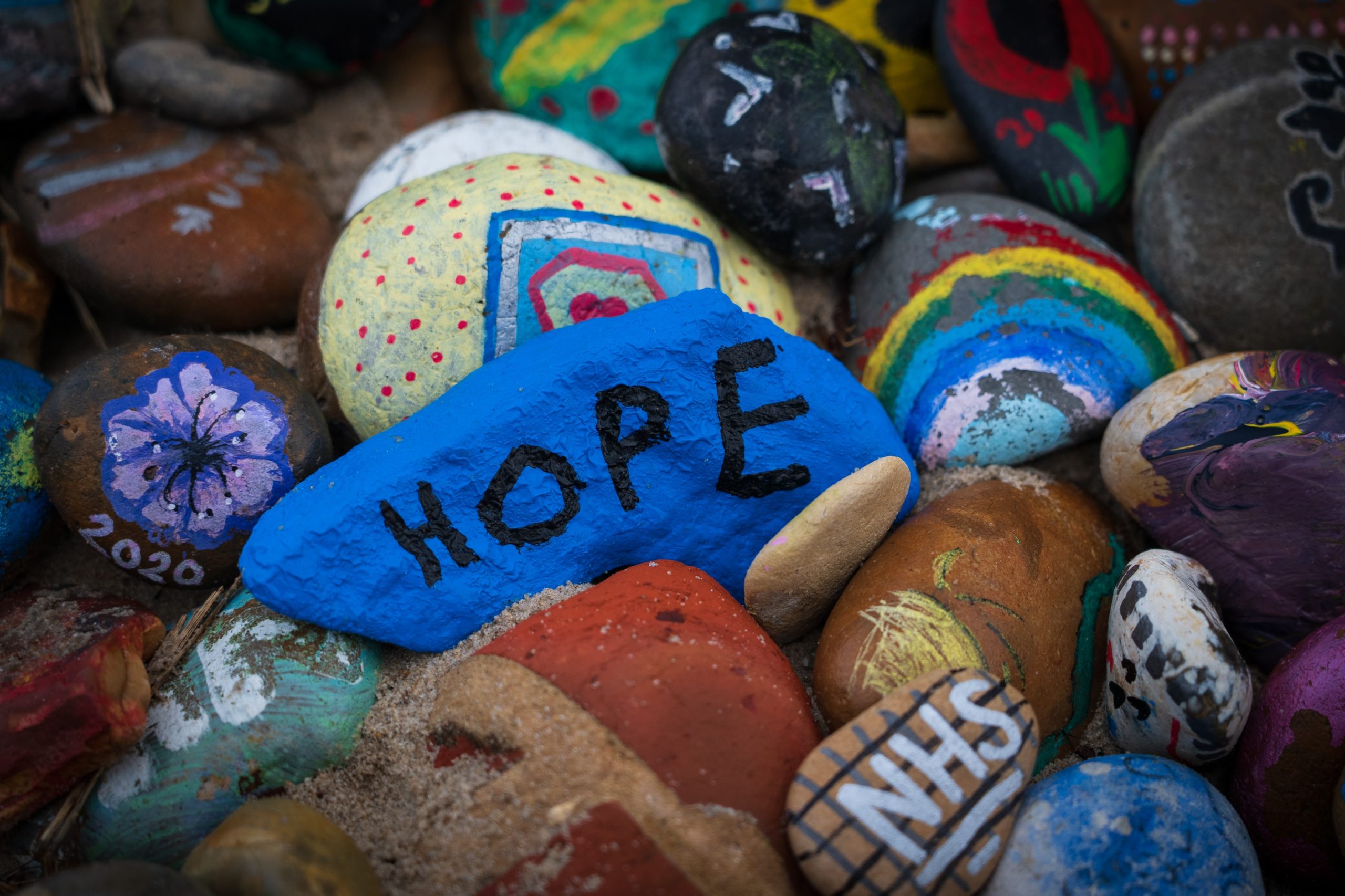 Painted pebbles, one with the word 'hope', and another with 'NHS'.