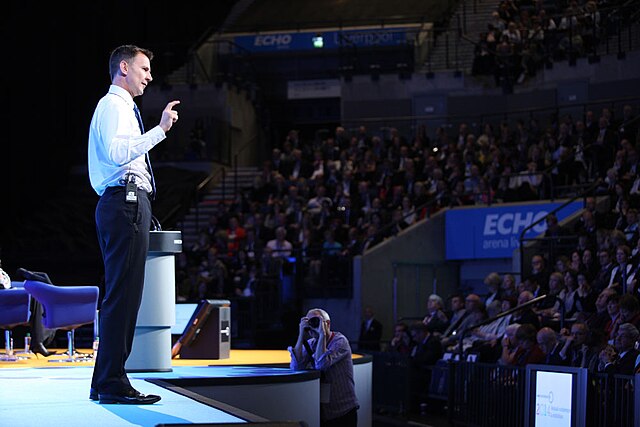 Jeremy Hunt MP, Chancellor of the Exchequer, addresses delegates at a conference.