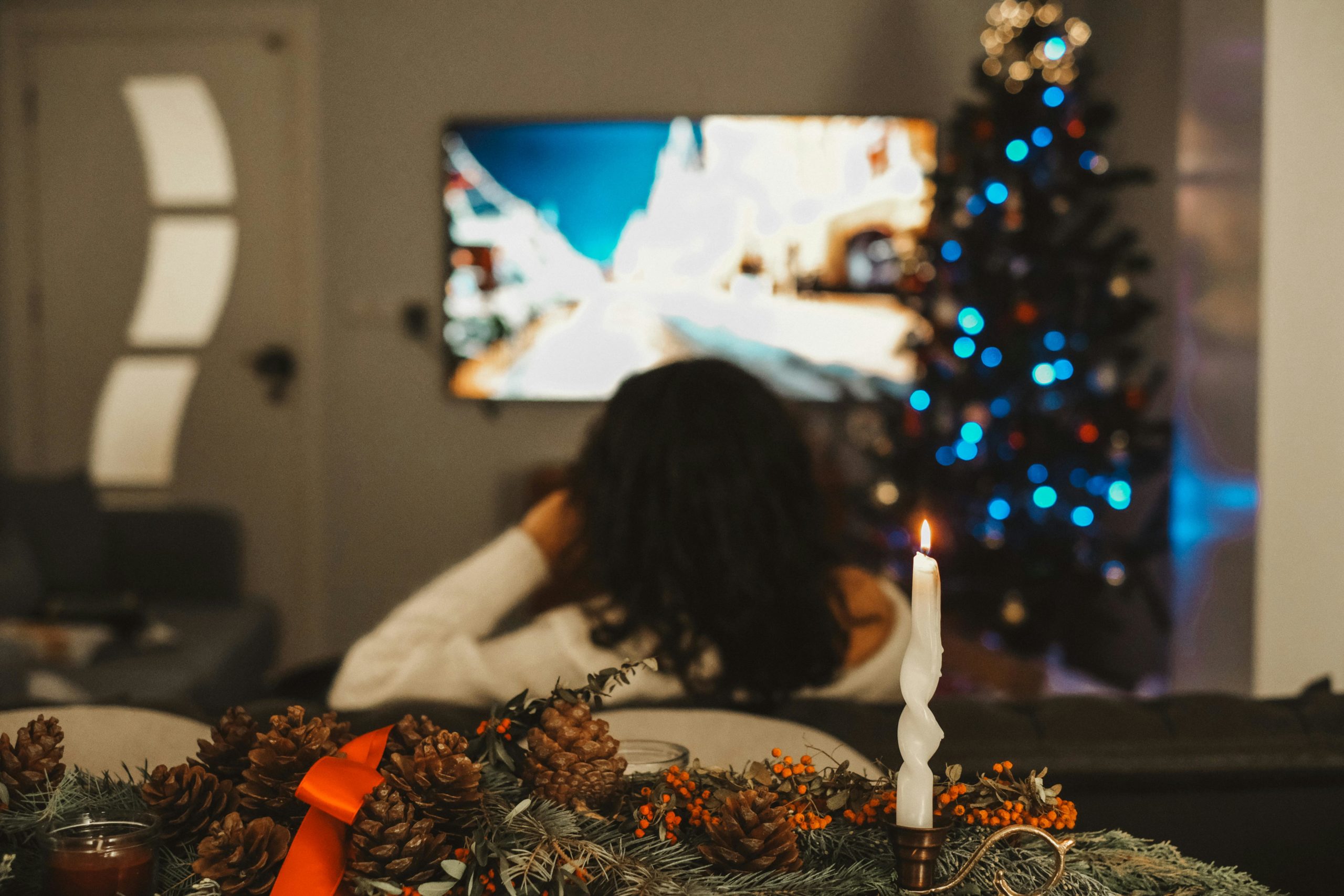 A woman watching TV in the living room at Christmas time