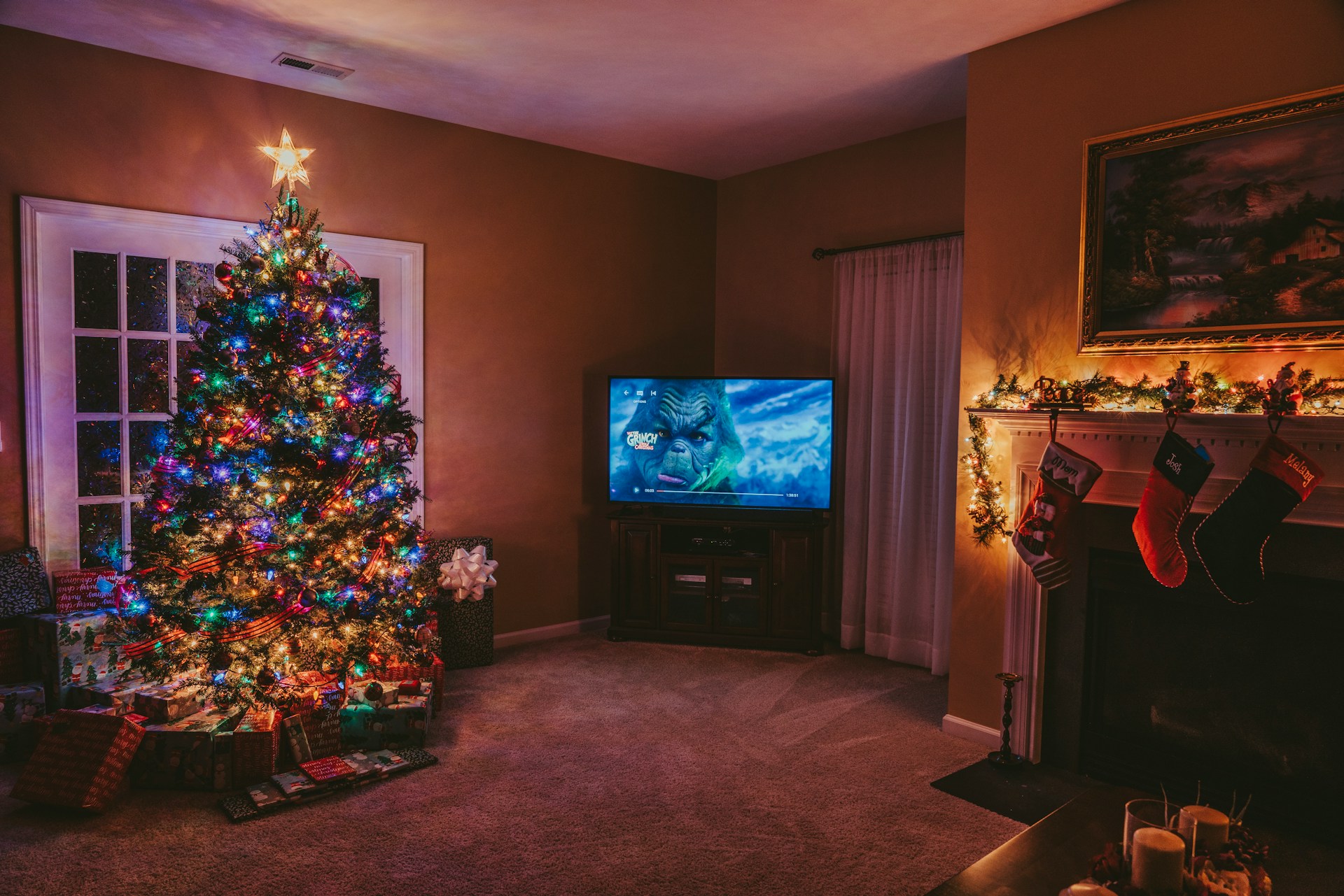 A living room with a Christmas tree and a TV playing a Christmas film