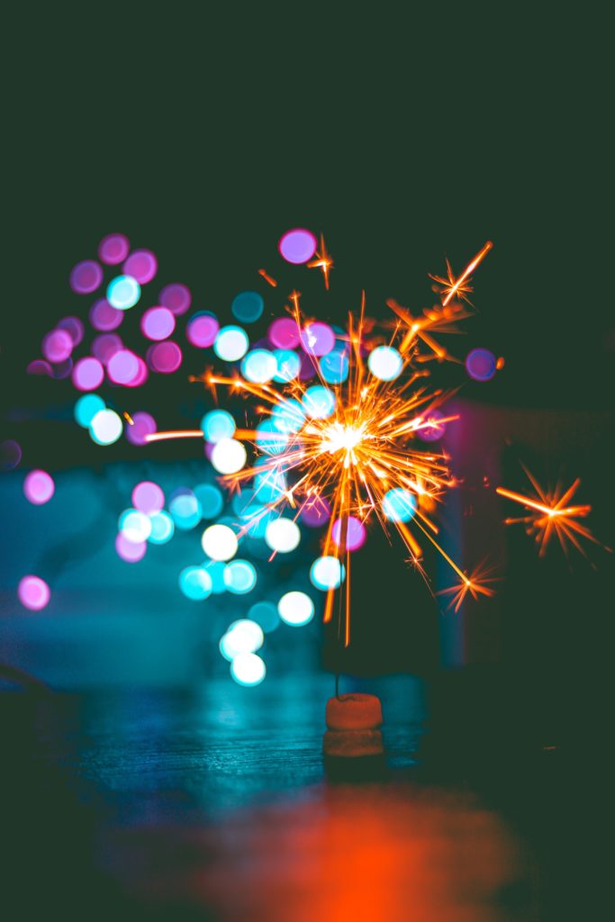 photograph of a sparkler giving off colourful sparks, to commemorate new year celebrations