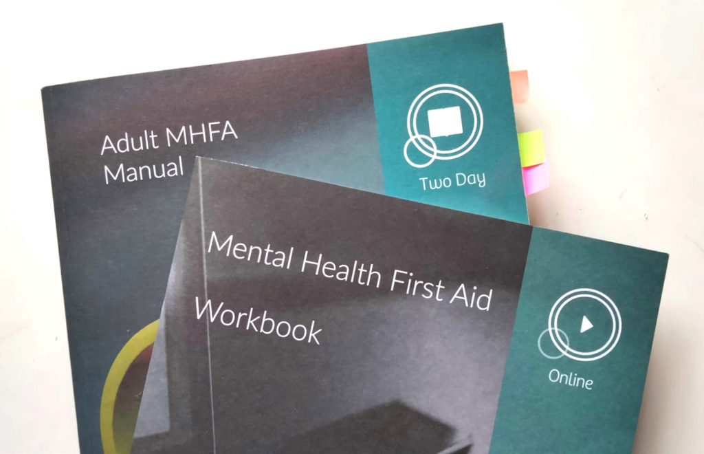 Image depicts two copies of the Mental Health First Aid workbook.