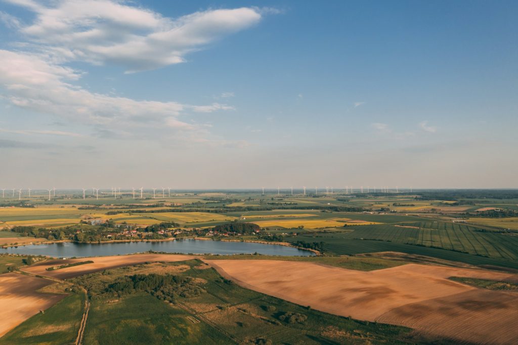 Current image: A landscape with a lake and wind turbines in the distance