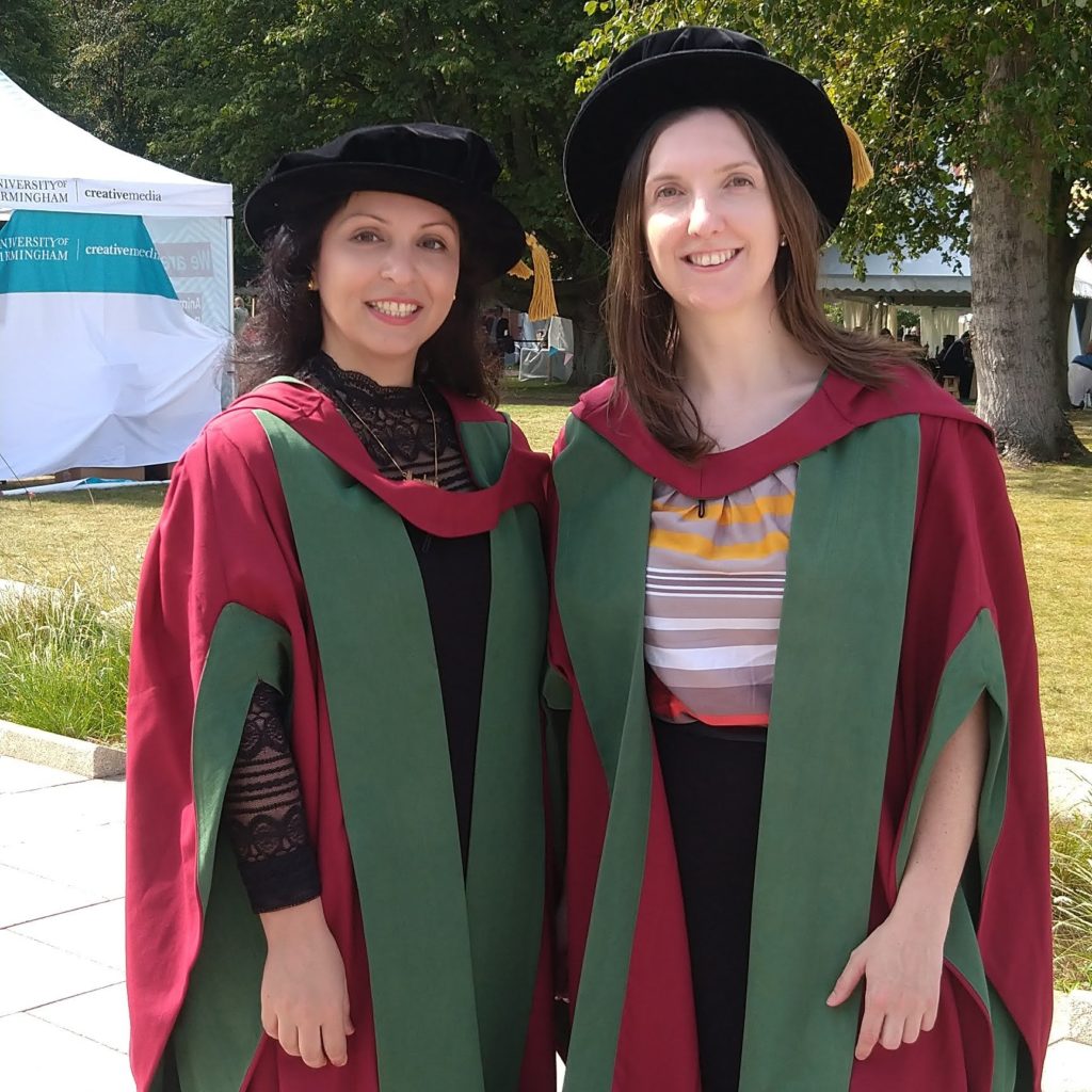 Mandana and Hannah, pictured in their graduation gowns on the University campus