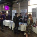 University of Birmingham marketing stand; Jared and Caleb talking to a student