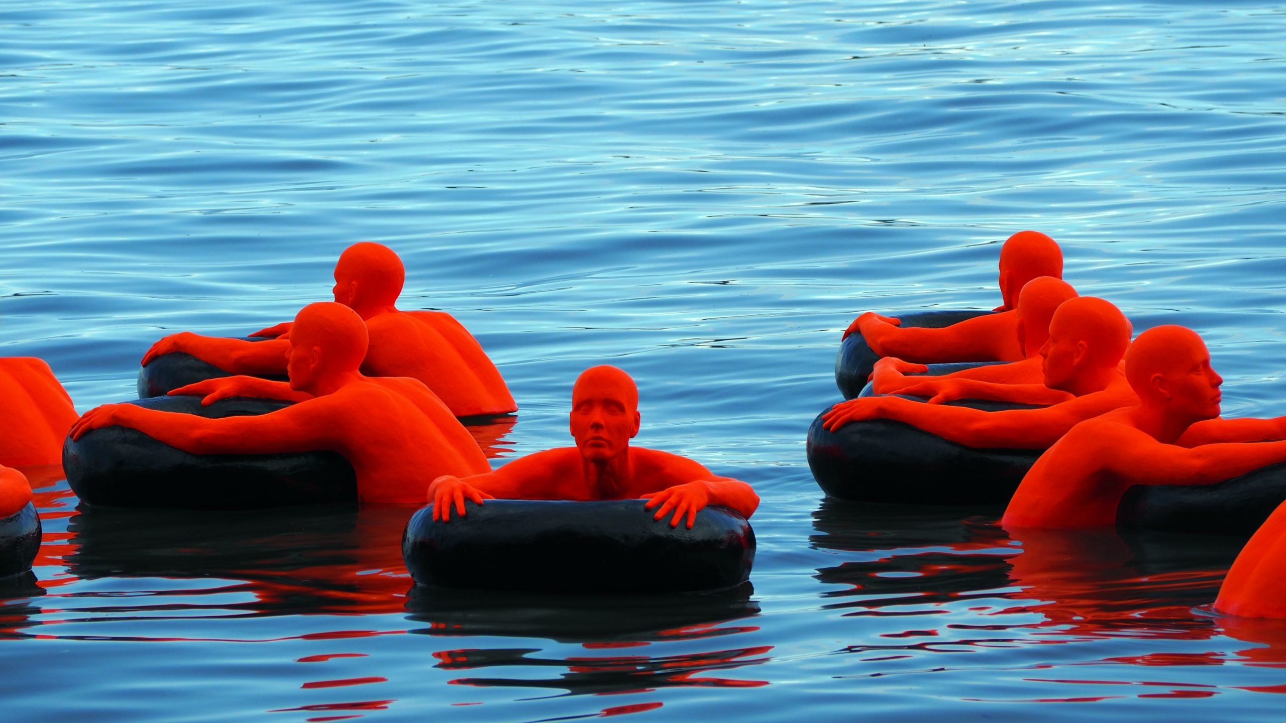Photo of statues that represent refugees trying to stay afloat in water