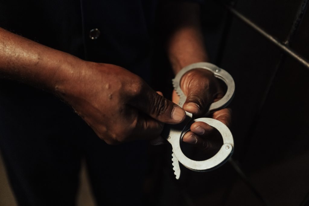 Photo of person holding hand cuffs