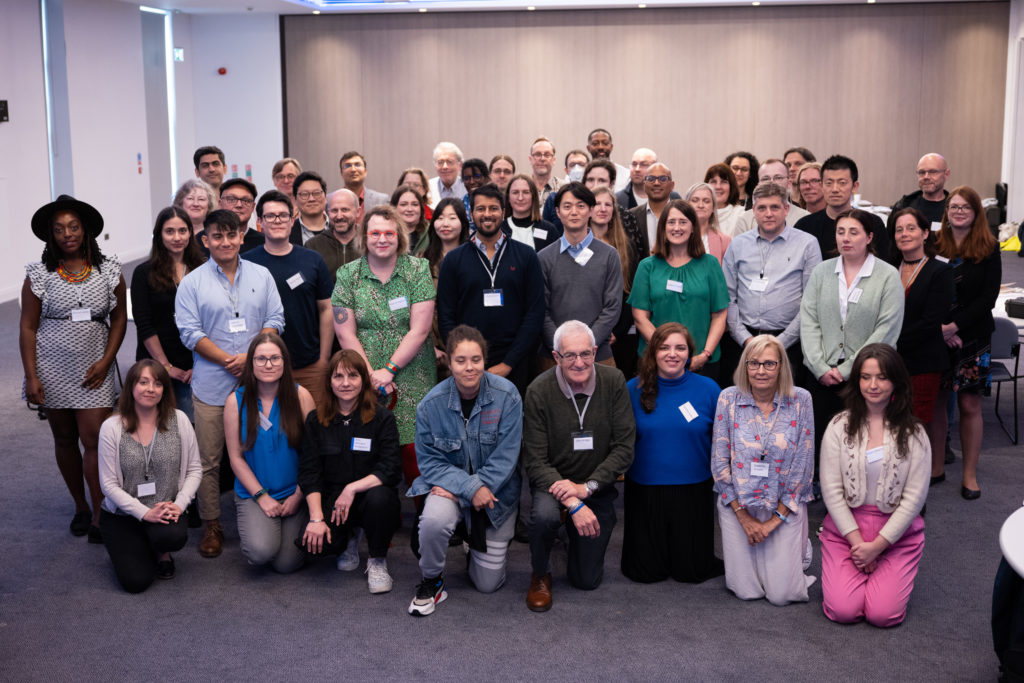 The images shows a large group of almost 50 people who took part in the SMQB Research Incubator. A wide range of ages, ethnicities and genders is featured.