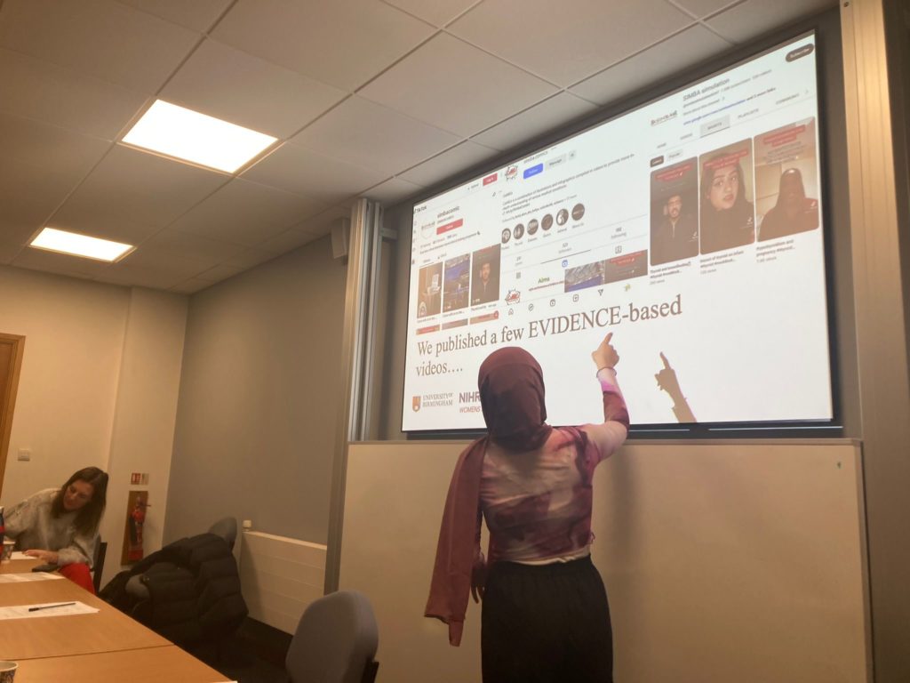 The image shows a woman giving a presentation to a group of other people. The purpose of the image is to show some of the training that took place in the event.